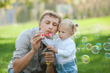 man and girl blowing bubbles